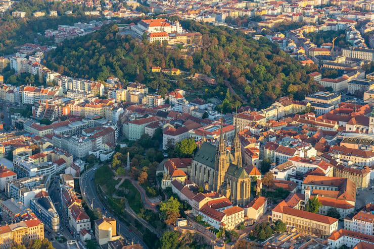 A scenic view of Lithuania showcasing historic architecture, green landscapes, and modern cityscapes reflecting the country's cultural and natural beauty.